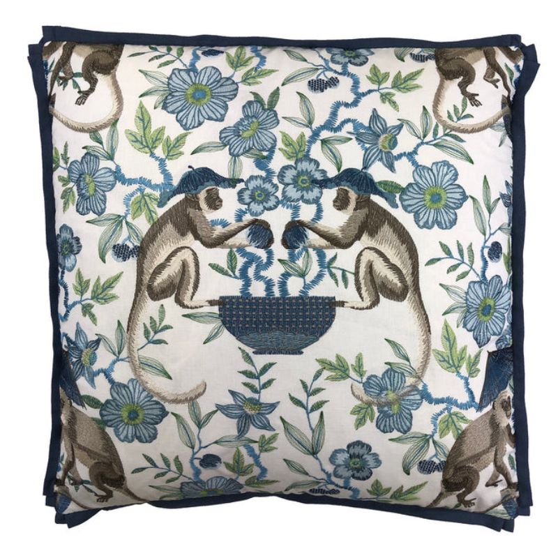 Decorative pillow with monkey and floral pattern on a white background