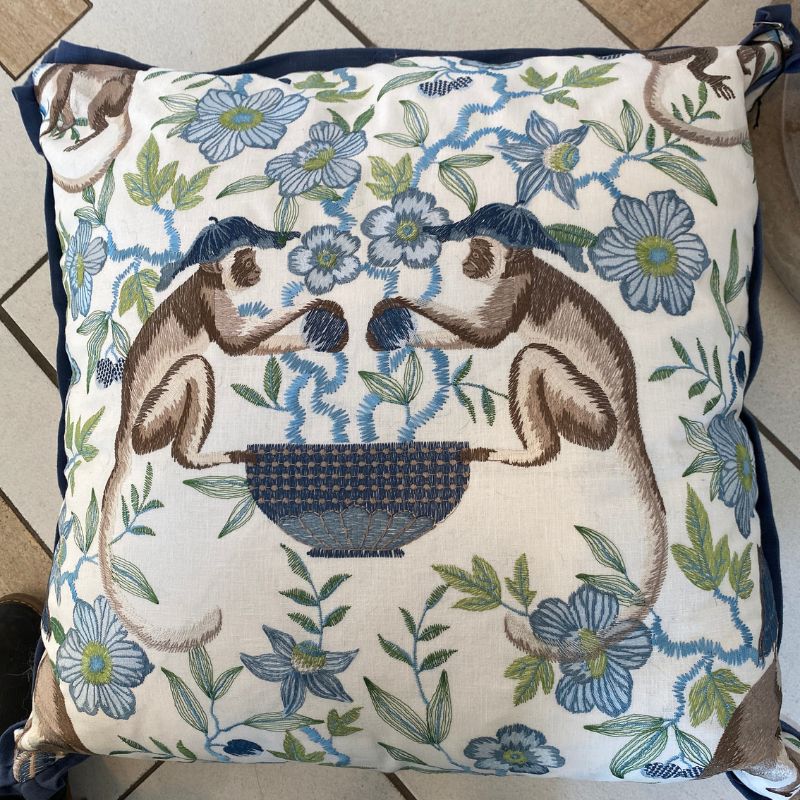 Decorative pillow with monkey and floral pattern on a tiled floor